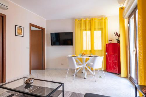 a living room with a table and a yellow curtain at Appartamento Nicoletta in Taormina