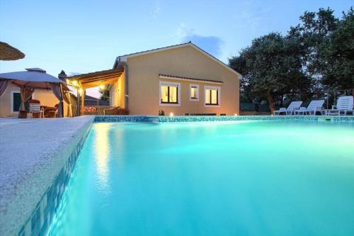 a swimming pool in front of a house at Ferienhaus mit Privatpool für 10 Personen ca 130 qm in Paradiž bei Vodnjan, Istrien Südküste von Istrien in Juršići