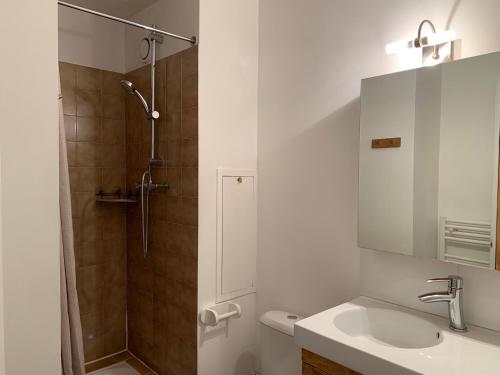 La salle de bains blanche est pourvue d'un lavabo et d'une douche. dans l'établissement Studio Les Menuires, 1 pièce, 2 personnes - FR-1-452-144, aux Menuires