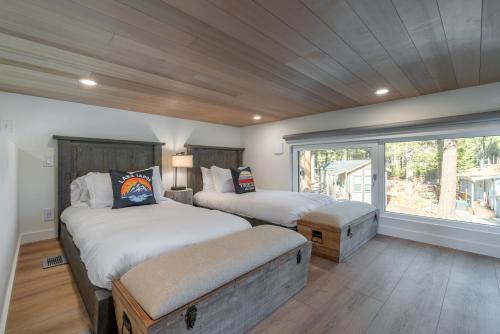 a bedroom with two beds and a large window at Village Camp in Truckee