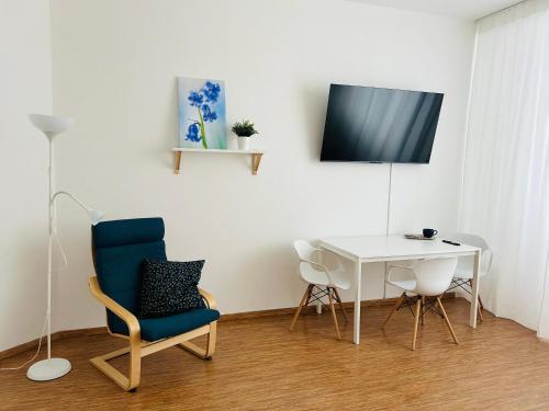 een kamer met een witte tafel en een blauwe stoel en een witte tafel bij Studio Apartment Bluebell in Bratislava
