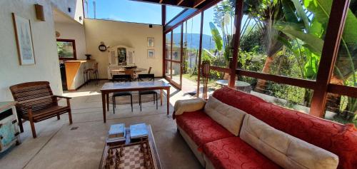 sala de estar con sofá rojo y ventana grande en Casa Bon Voyage - Guesthouse en Paraty