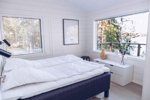 ein weißes Schlafzimmer mit einem Bett und einem Fenster in der Unterkunft Villa Jumo Iniö in Iniö