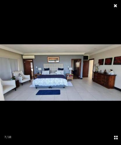 a large bedroom with a bed and a couch at Beach House in Glenashley in Durban