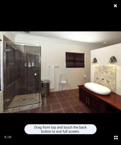 a bathroom with a shower and a sink at Beach House in Glenashley in Durban
