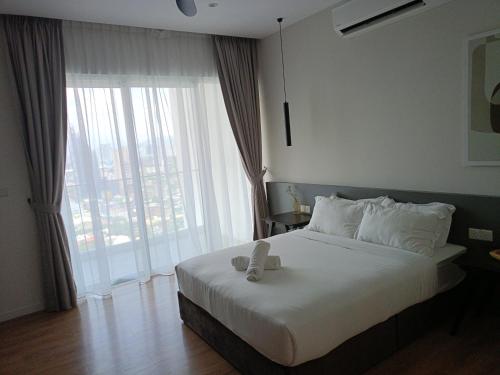 a bedroom with a bed and a large window at QUILL APARTMENT SKY 1018 in Kuala Lumpur