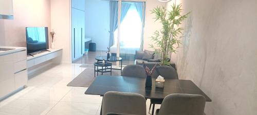 a living room with a table and chairs and a television at QUILL APARTMENT SKY 1018 in Kuala Lumpur