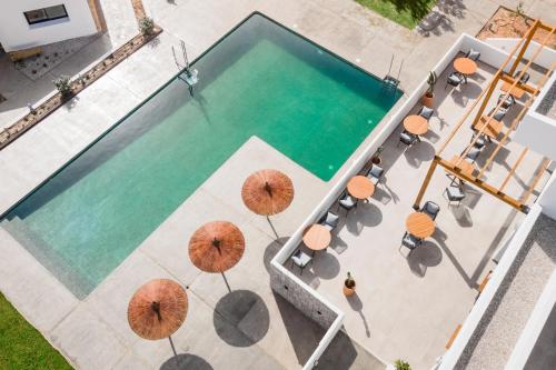 einen Blick über einen Pool mit Sonnenschirmen in der Unterkunft Hotel Boutique Mi Almazara in Jávea