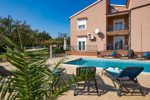 eine Villa mit einem Pool, Stühlen und einem Haus in der Unterkunft Ferienhaus für 10 Personen in Belavici, Istrien Bucht von Raša - b54750 in Hreljići