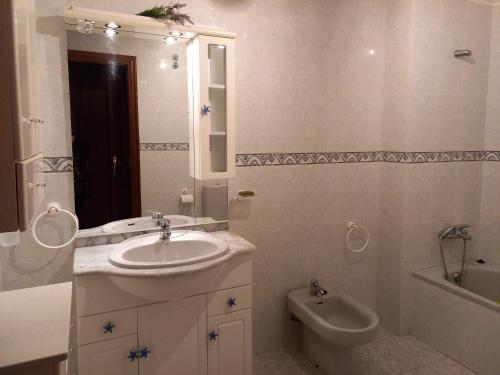 een badkamer met een wastafel, een toilet en een bad bij Vacaciones in Cedeira