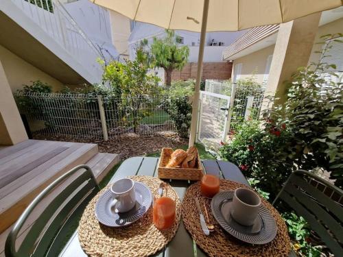 a table with two plates and a basket of bread at BELAZUR Entre plage et port in Bandol