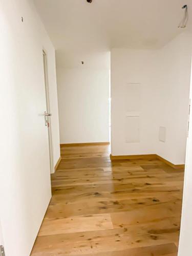 Cette chambre vide est dotée de parquet et de murs blancs. dans l'établissement in der nähe von Lucern (30 Minuten) & 1 Stunde von Zürich, à Gontenschwil