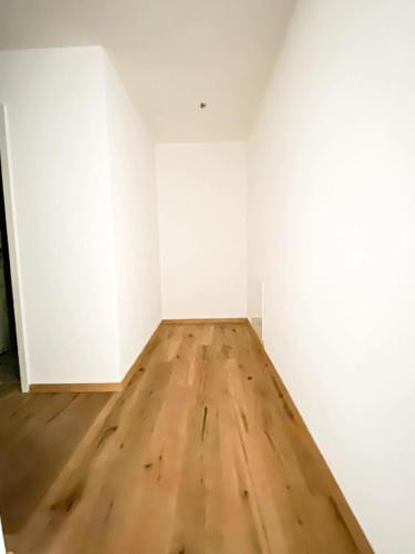 Cette chambre vide est dotée de murs blancs et de parquet. dans l'établissement in der nähe von Lucern (30 Minuten) & 1 Stunde von Zürich, à Gontenschwil