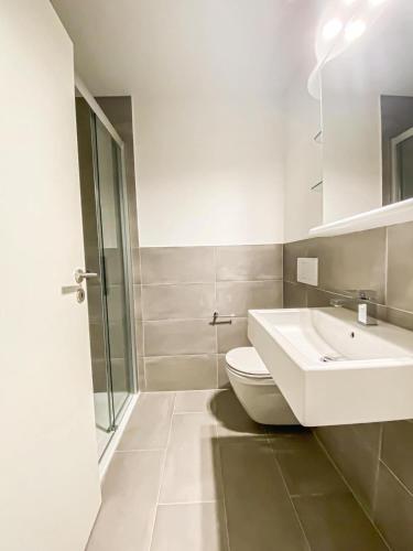La salle de bains est pourvue d'un lavabo blanc et de toilettes. dans l'établissement in der nähe von Lucern (30 Minuten) & 1 Stunde von Zürich, à Gontenschwil