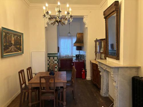 ein Esszimmer mit einem Tisch und einem Kronleuchter in der Unterkunft Belle Epoque flat in the heart of Ostend in Ostende