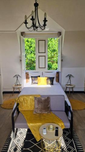 a bedroom with a bed and a couch and two windows at L'Oasis de BK in Pointe-à-Pitre