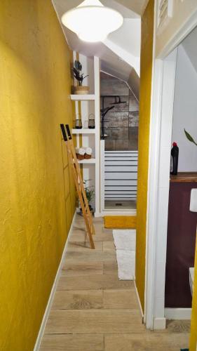 a hallway with yellow walls and a wooden floor at L'Oasis de BK in Pointe-à-Pitre