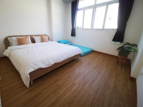 1 dormitorio con 1 cama grande y suelo de madera en Proud Room & wifi en Pattaya North
