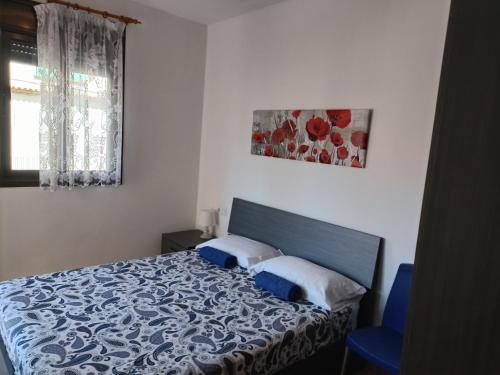 a bedroom with a bed with a blue and white comforter at Piso Andrea in Lloret de Mar