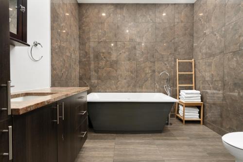 a bathroom with a tub and a sink at Boutique Lofts Notre Dame in Montréal