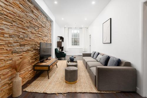 a living room with a couch and a brick wall at Boutique Lofts Notre Dame - Vieux Montréal in Montréal