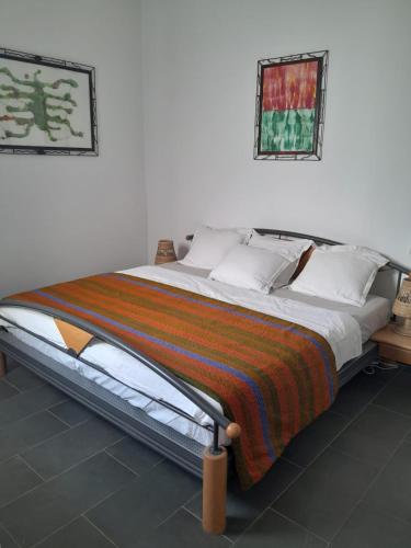 a bedroom with a large bed with a striped blanket at Studio Cozy in Sali Tapé