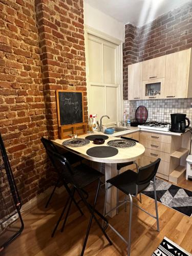a kitchen with a table and a brick wall at Apartment in Great Location in Kadıkoy Seaside w. Amazing Shared Terrace in Istanbul