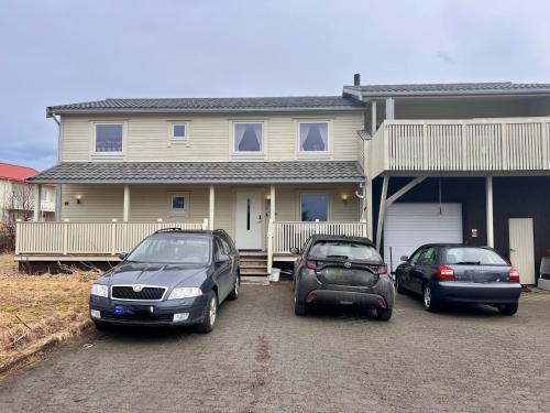 dos autos estacionados frente a una casa en Lofoten booking en Leknes