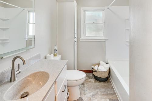 a white bathroom with a toilet and a sink at Pet-Friendly Sioux Falls House - 2 Mi to Downtown! in Sioux Falls