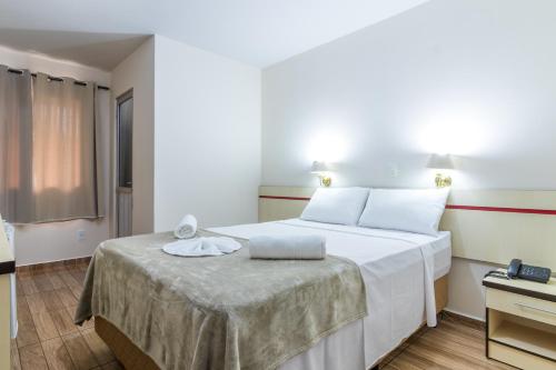Una habitación de hotel con una cama con una toalla. en Foz Budget Hotel, en Foz do Iguaçu