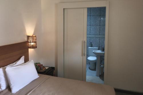 ein Schlafzimmer mit einem Bett und ein Badezimmer mit einem WC in der Unterkunft Pousada Panorama Cipo in Santana do Riacho