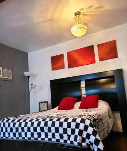 a bedroom with a black and white bed with red pillows at Casa esmeralda in Chihuahua