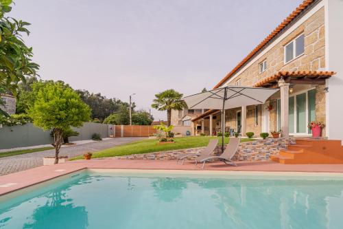 a swimming pool in front of a house at Casa Maria - Paraíso Rural in Jesufrei