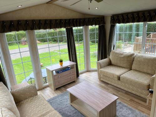 a living room with a couch and a table at Natland Caravan Park in Kendal