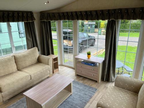a living room with a couch and a table at Natland Caravan Park in Kendal