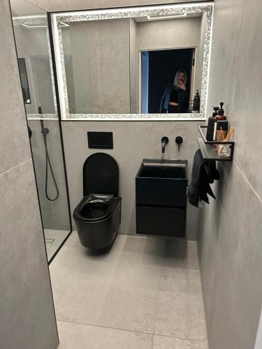 Eine Frau fotografiert ein Bad mit WC und Waschbecken in der Unterkunft Riversdale House Next to Murrayfield Stadium in Edinburgh