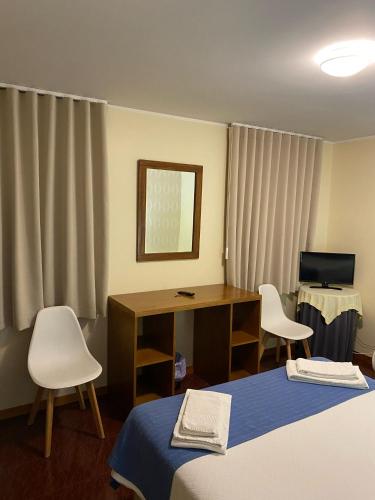 a room with two beds and a desk and a computer at Enjoy Viana - Guest House in Viana do Castelo