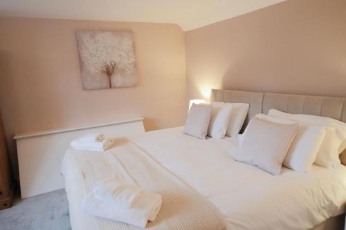 a bedroom with a white bed with white pillows at Lambert Cottage - In the Heart of Stamford in Stamford