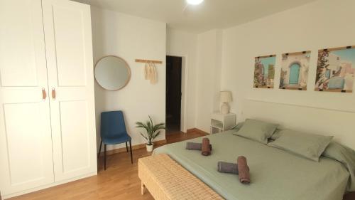 um quarto com uma cama e uma cadeira azul em Sea La Vie Tabaiba - Piscina, Parking & Tenis em Tabaiba