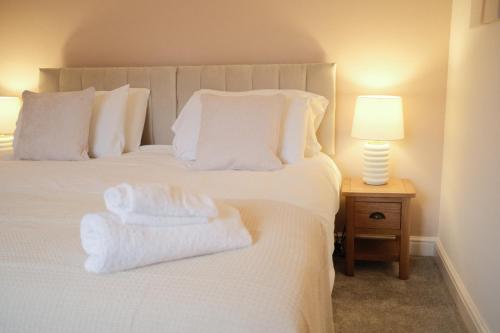 a bedroom with a white bed with towels on it at Lambert Cottage - In the Heart of Stamford in Stamford