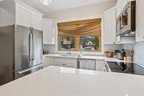 a kitchen with white cabinets and a window at The Appalachian in Blowing Rock