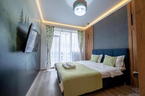 a bedroom with a large bed with a window at Cross Caraiman View 2 in Buşteni