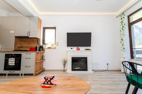 a living room with a fireplace and a tv on the wall at Cross Caraiman View 2 in Buşteni