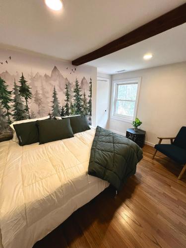 a bedroom with a large bed with a painting on the wall at Waterfront Lakehouse Getaway in Clinton with HOT TUB in Clinton