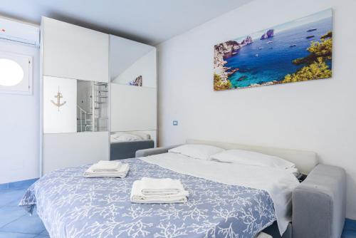 1 dormitorio blanco con 1 cama con 2 toallas en Appartamento Relais sul mare 6 ospiti, en Meta