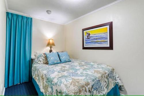ガルベストンにあるCharming Ocean View Condoのベッドルーム1室(青いカーテン付きのベッド1台付)