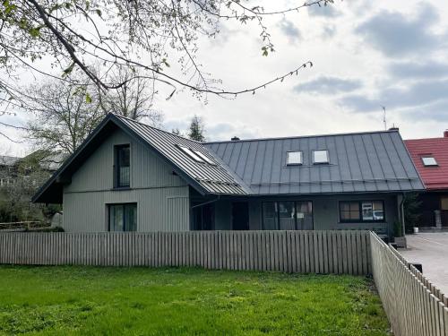 a house with a metal roof and a fence at Private Trakai Historical Centre Karaim Two Floor Apartment in Trakai