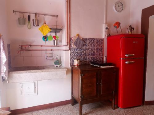 uma cozinha com um frigorífico vermelho e um lavatório em Casetta dei Nonni em Vitorchiano