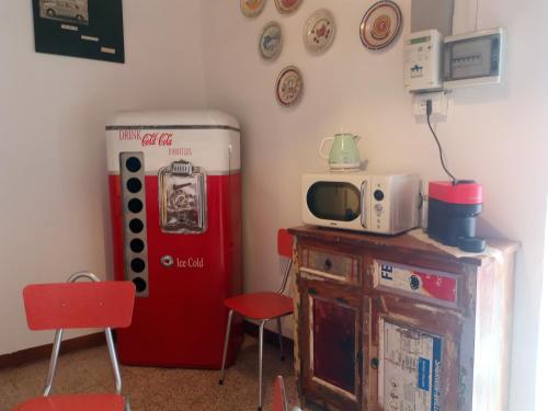 a room with a red refrigerator and a microwave at Casetta dei Nonni in Vitorchiano