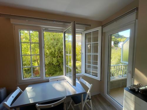 una sala da pranzo con finestre, tavolo e sedie di La Puerta del Valle a Villafranca del Bierzo